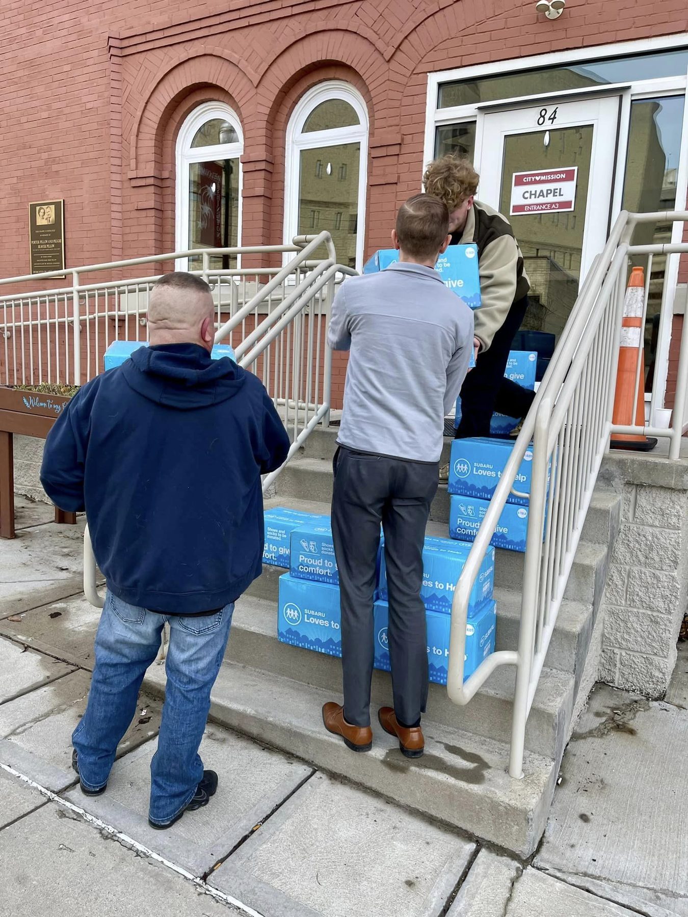 Two people carrying delivery boxes up a set of steps